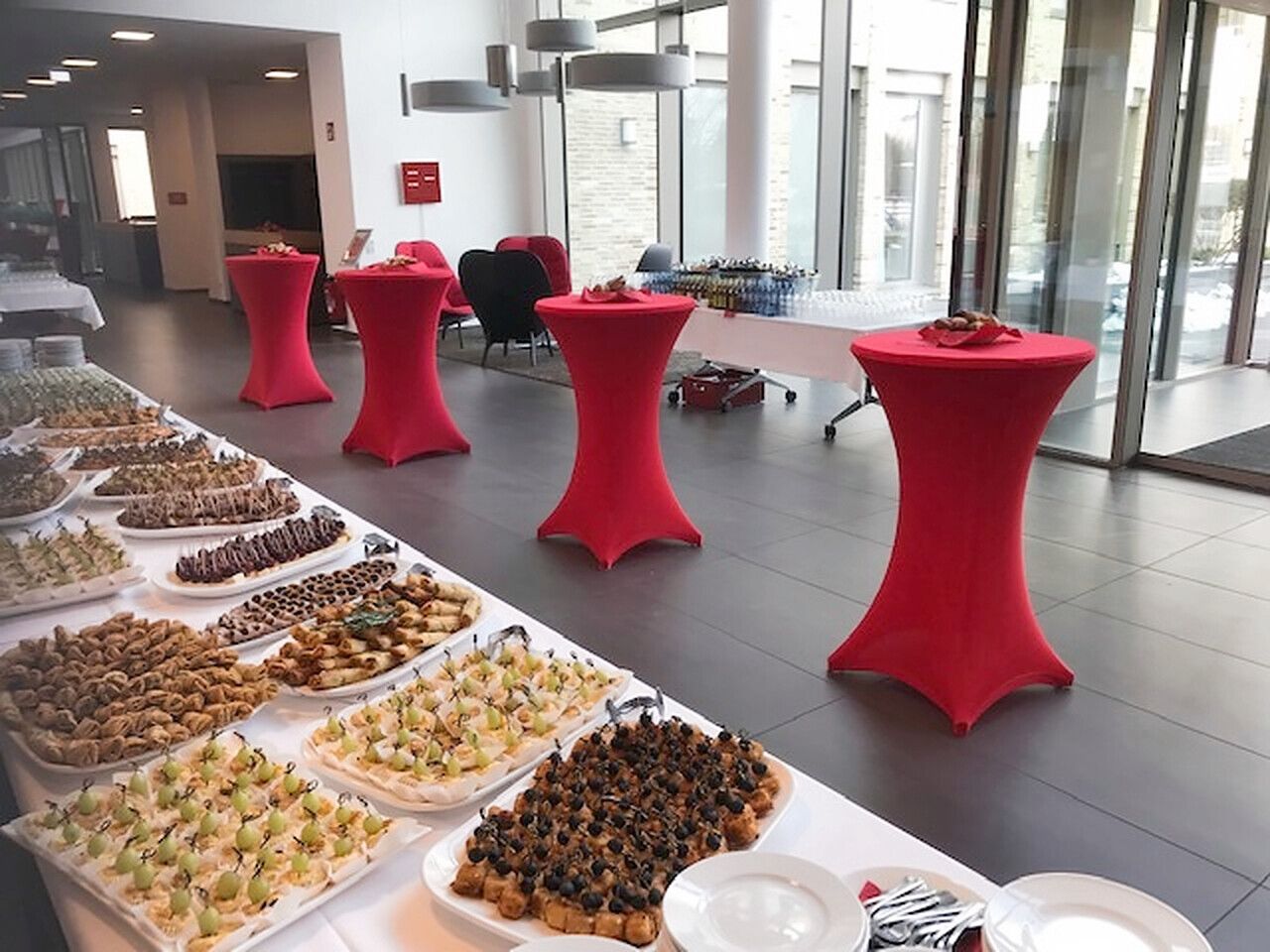 Fingerfood-Buffet mit Stehtischen bei einem Firmenempfang