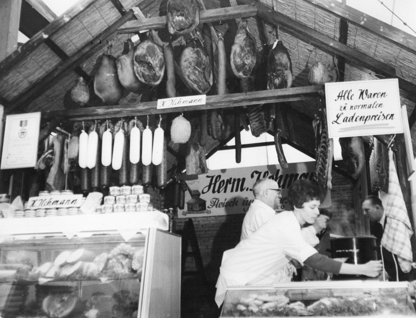 Hermann Ilchmann an seinem Verkaufsstand mit dem Schild Herm. Ilchmann Fleisch- und Wurstwaren