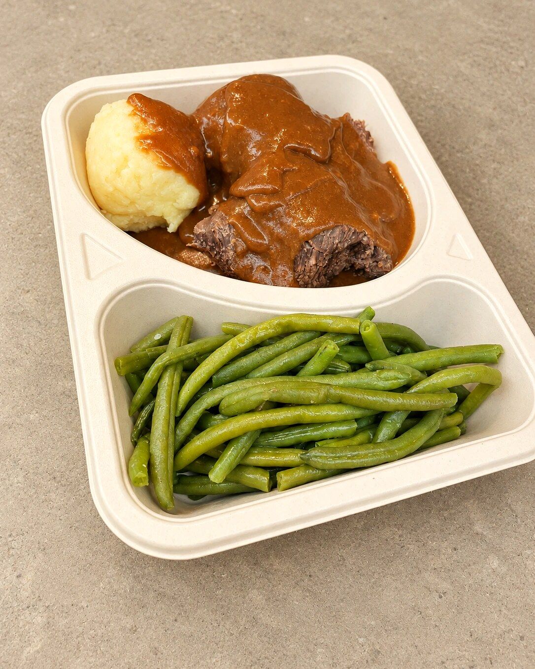 Rinderroulade mit Kartoffelpüree und grünen Bohnen in der Schale zum Mitnehmen